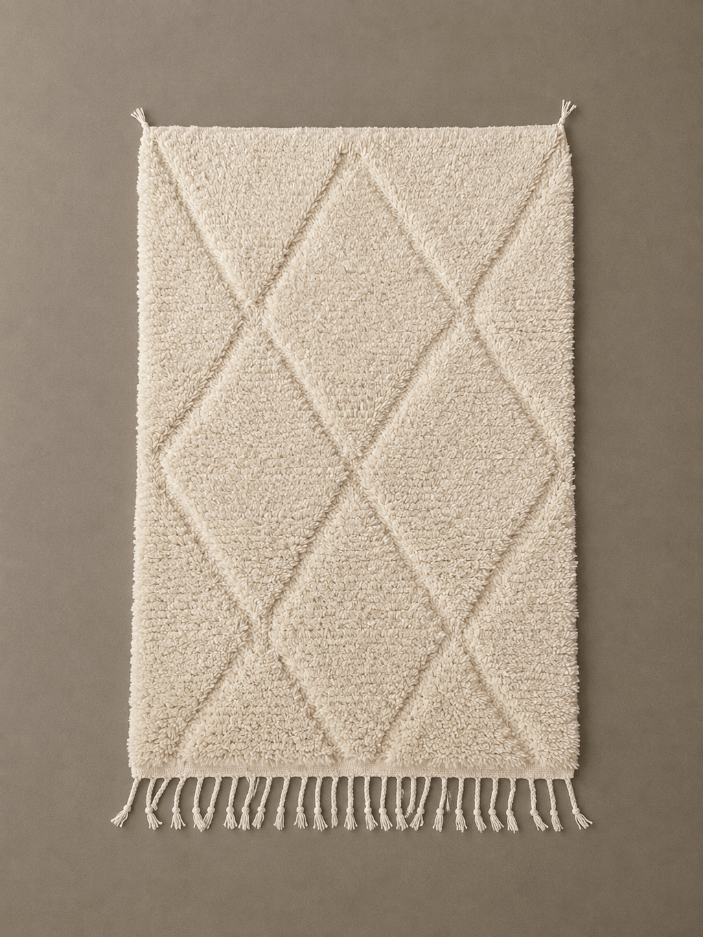 Handmade cream Moroccan Berber wool rug with a diamond pattern and fringed edges.