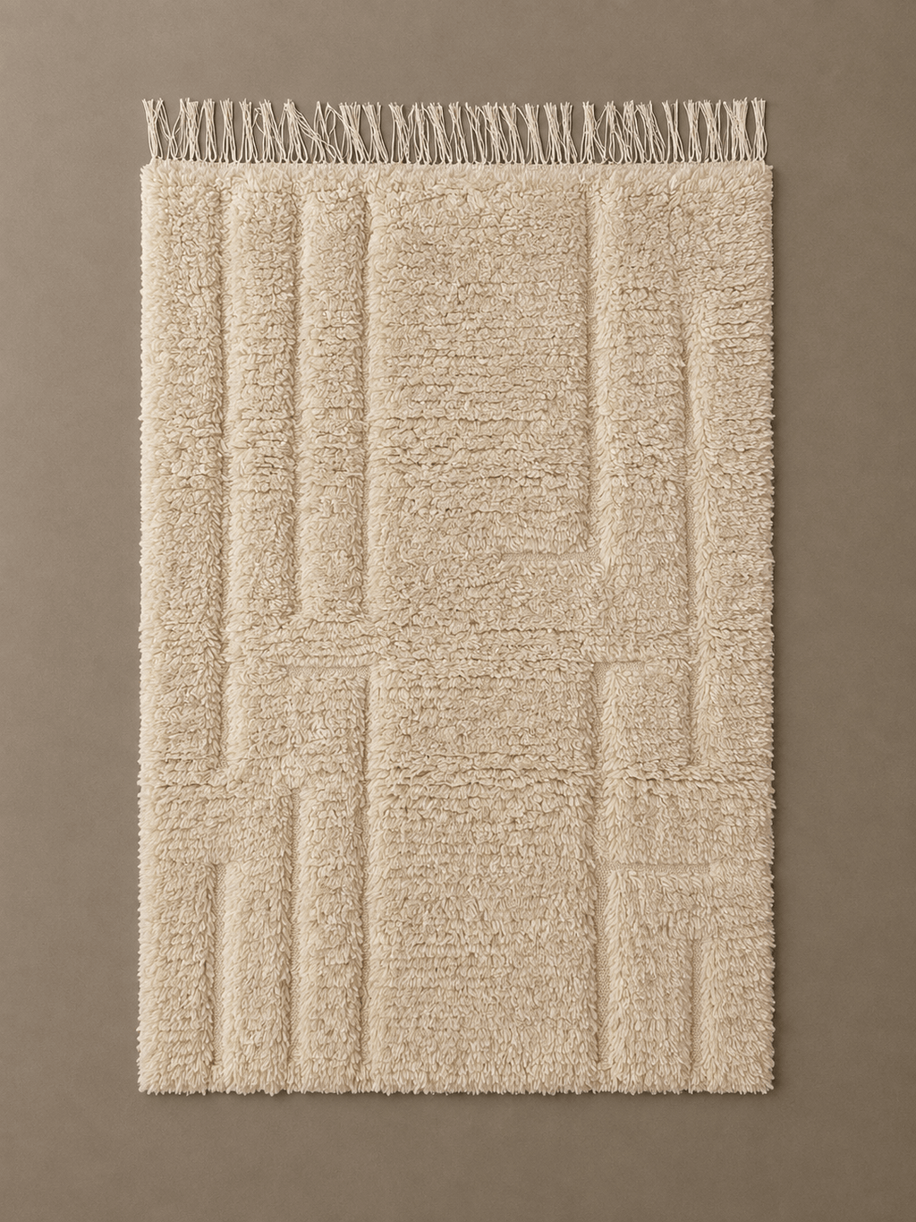 tapis Beni Ouarain motifs écru Handmade beige wool Moroccan Berber rug with a textured geometric pattern and fringed edge.