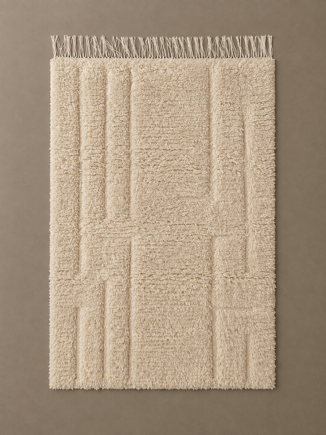 tapis Beni Ouarain motifs écru Handmade beige wool Moroccan Berber rug with a textured geometric pattern and fringed edge.