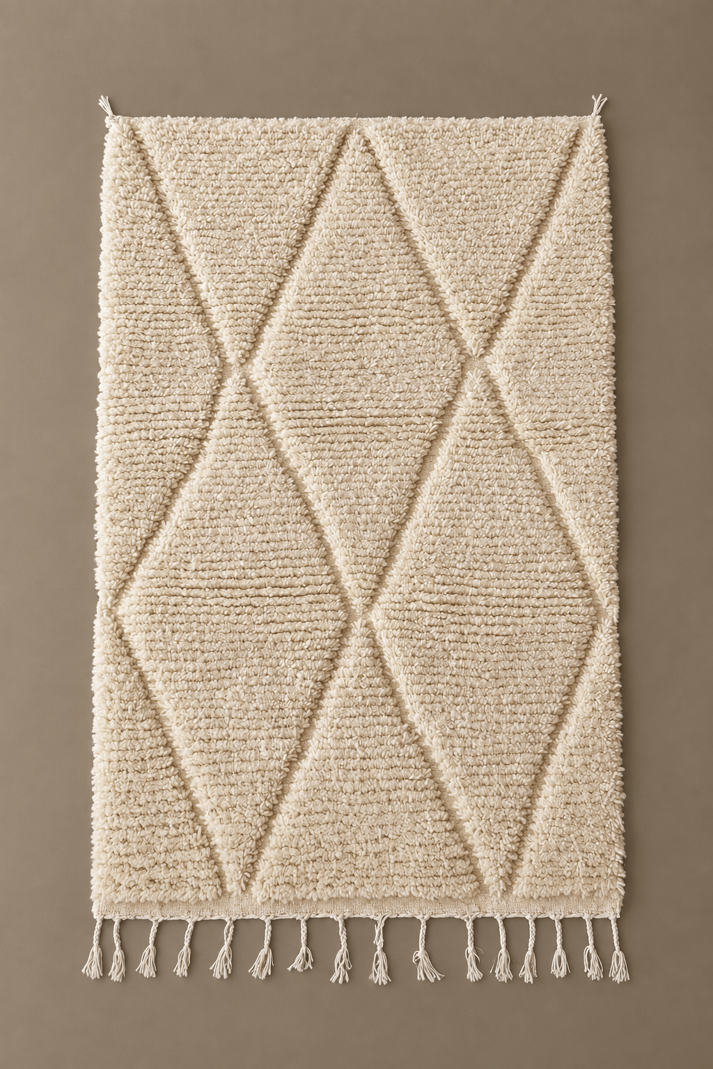 Handmade cream wool Moroccan Berber rug with a textured diamond pattern and fringe tassels.